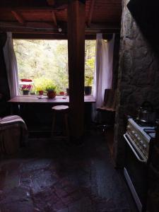 a kitchen with a window and a table and a stove at Hostal Nunatak in La Porteña