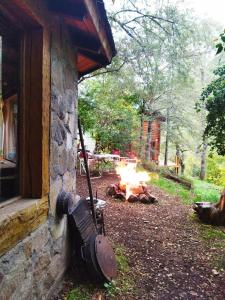 a fire pit in front of a stone building at Hostal Nunatak in La Porteña