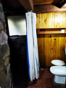 a bathroom with a toilet and a shower curtain at Hostal Nunatak in La Porteña +3 photos