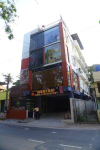 a building on a street with people standing in front of it at Raj Hussain Land Mark Hotel in Mayiladuthurai
