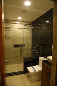 a bathroom with a shower and a toilet and a sink at Raj Hussain Land Mark Hotel in Mayiladuthurai