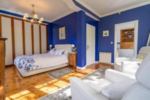 a blue bedroom with a bed and a couch at Villa Elena in Potes