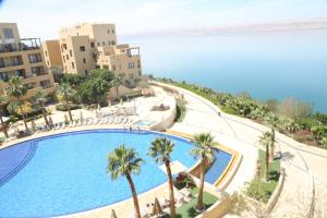 an overhead view of a swimming pool with palm trees and buildings at Samarah Resort Apartment D32 at DeadSea, Sea & Pool view- Families & couples only in Sowayma