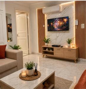 a living room with a couch and a tv on a wall at Modern and Calm Apartment in Mahdia near Beach in Rejiche