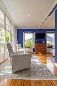 a living room with blue walls and white furniture at Villa Elena in Potes
