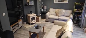 a living room with a white couch and a tv at Clifden Glen House in Clifden
