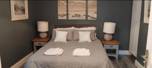 a bedroom with a bed with two lamps and towels on it at Clifden Glen House in Clifden