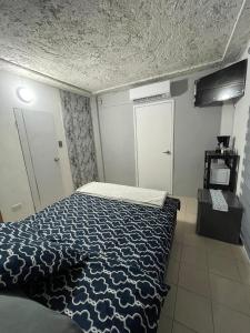 a bedroom with a bed with a blue comforter at Suite De Descanso En Urbanización Residencial FRENTE AL AEROPUERTO in Maiquetia