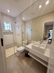 a bathroom with a toilet and a sink and a shower at Pousada Casa Hospedaria in Paraty