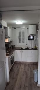 a kitchen with white cabinets and a sink and a stove at casa Caithlyn in Peniscola