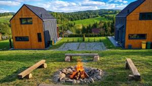 a fire pit in the middle of a yard with two barns at Stodoły ForRest in Czarna