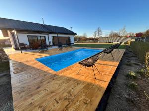 a swimming pool with a chair on a wooden deck at Piasutno in Piasutno
