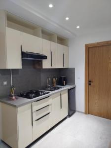 a kitchen with white cabinets and a stove at Riad Andalous in Ariana