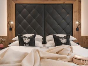 a bedroom with a large bed with white sheets and pillows at Landhaus Mader Hintertux in Tux