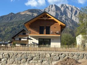 a house with a fence in front of a mountain at Sportchalet Bergkristall regio Nassfeld Presseggersee in Kirchbach