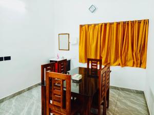 a room with a desk and two chairs and a yellow curtain at Nilavu villas in Alleppey +20 photos