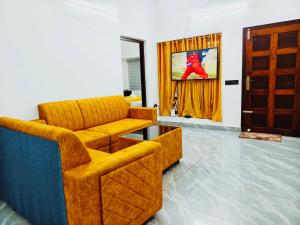 a living room with a couch and a chair at Nilavu villas in Alleppey