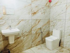 a bathroom with a toilet and a sink at Nilavu villas in Alleppey