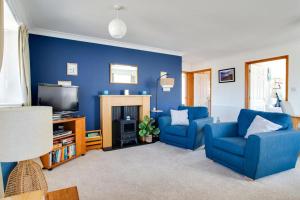 a blue living room with two blue chairs and a tv at 2 Bed in Walcott oc-2301 in Walcott