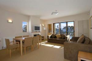 a living room with a couch and a table and chairs at Chalet Hotham 1 in Mount Hotham