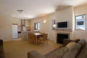 a living room with a couch and a table and a kitchen at Chalet Hotham 1 in Mount Hotham