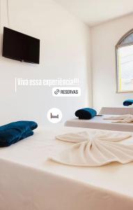 two beds in a room with a tv on the wall at Hotel Dairy Walley in Itapetinga