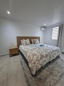 a bedroom with a bed and a night stand at Appartement Mango in Rivière-Salée