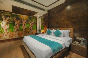 a bedroom with a bed with a painting on the wall at Hotel Heritage Street ! 100m from Golden Temple ! Parking & Restaurant in Amritsar +60 photos