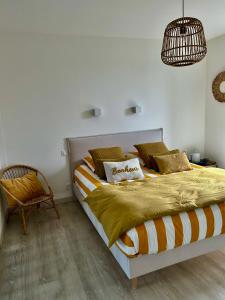 a bedroom with a bed and a chair at Etoile du Kap in Barneville-Carteret