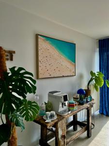 a table in a room with a picture of a beach at Etoile du Kap in Barneville-Carteret