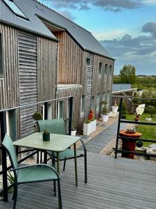 a patio with a table and chairs on a deck at Etoile du Kap in Barneville-Carteret