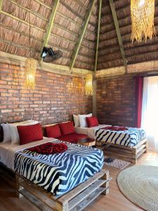 two beds in a room with a brick wall at Villa Rosa in Moshi