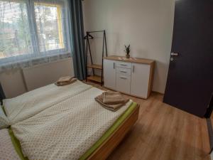 a bedroom with a bed and a dresser and a window at Apartmán Gerlach in Vyšné Hágy