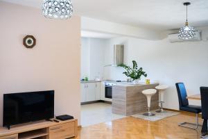 a living room with a tv and a kitchen at Apartman VITINA in Ljubuški