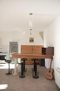 a large wooden piano in a room with a guitar at Casa Juanca in Comodoro Rivadavia