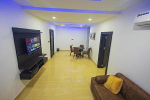 a living room with a couch and a flat screen tv at Diplomats Enclave Suites in Jikoyi