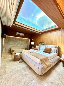 a large bedroom with a large bed with a skylight at SDesign Paraty Hotel in Paraty
