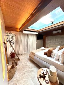 a bedroom with a large bed with a large window at SDesign Paraty Hotel in Paraty