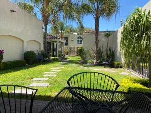 a bench in the yard of a house with palm trees at Estancia Santa Fe in Celaya