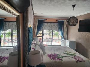 a bedroom with a large bed and a large window at PJ Guesthouse in Welkom