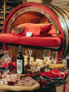 a table with wine glasses and a bed in a barrel at Al Silter in Capriate San Gervasio