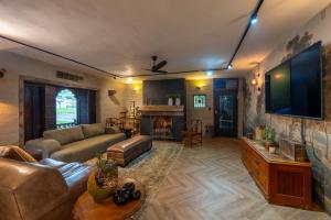 a large living room with a couch and a tv at River House Lodge in Malelane