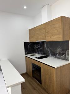 a kitchen with wooden cabinets and a stove top oven at Petro Rooms and View in Laç
