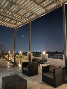 a patio with a table and chairs on a roof at night at Families Pyramids view - Rooftop in Cairo +50 photos