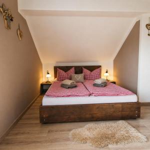 a bedroom with a bed with red sheets and pillows at Ferienwohnung Weber Alpenveilchen in Lechbruck