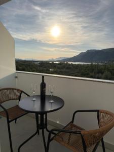 a table and two chairs with wine glasses on a balcony at Petro Rooms and View in Laç