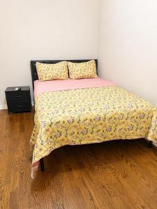 a small bedroom with a bed with a yellow bedspread at Anne room A in Irvington