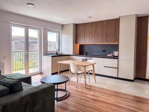 a living room with a table and a kitchen at Modern Spacious Mountain View Apt in Braşov