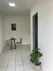 a room with a table and a potted plant at Hospedagem Sousa in Santa Inês