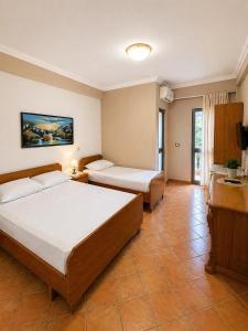 a hotel room with two beds and a television at Hotel Villa Megi in Golem +19 photos